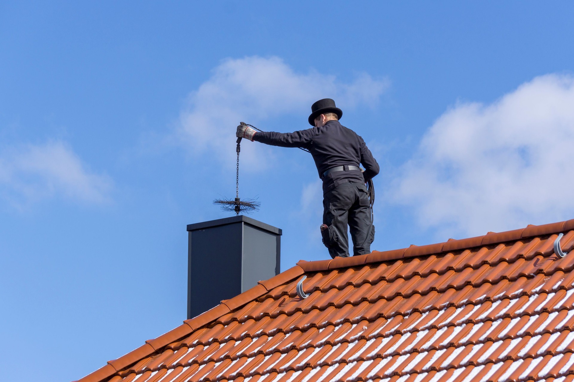 Chimney sweep cleans the chimney during the annual maintenance.